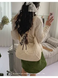 Versatile cream crochet woven beach bag for women shown in lifestyle shoulder carry view