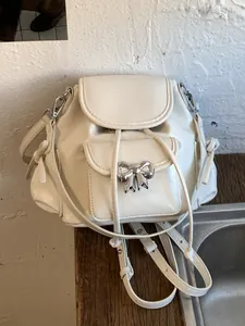 Stylish sweet white girl's backpack featuring silver ribbon bow detail for daily travel