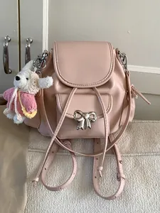 Sweet pink mini backpack for girls featuring a cute bow detail and plush rabbit charm