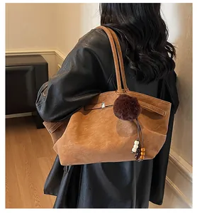 Brown vintage pleated tote bag with faux fur pom pom charm on shoulder