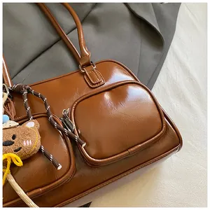 Dettaglio ravvicinato di borsa a tracolla vintage marrone in similpelle con tasche a zip