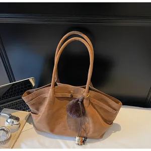 Vintage brown pleated faux leather tote bag featuring a decorative fluffy pom-pom charm detail