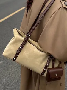 Elegante borsa a cuscino beige con cinturini in pelle marrone, borchie e mini busta