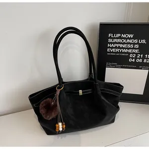 Vintage black pleated tote bag with plush charm on a minimalist background
