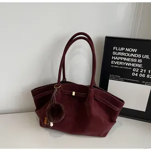 Side view of vintage burgundy pleated tote bag with plush pom-pom and bead pendant detail