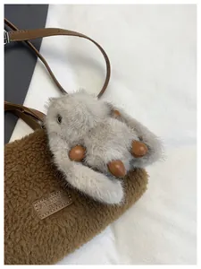 Λεπτομέρεια καφέ τσάντας fleece με ένα χαριτωμένο γκρι κουνελάκι και δερμάτινο λουράκι ώμου.