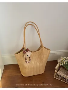 Elegant vintage-style woven tote bag with cute bear charm for daily commute
