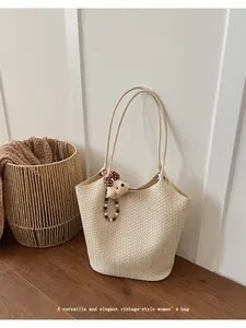 Vintage cream woven tote bag featuring a high-quality texture and cute bear charm.