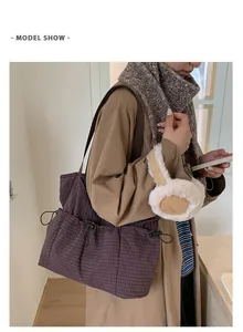 Große karierte Canvas-Einkaufstasche in einem Lifestyle-Modellfoto für den Alltag.