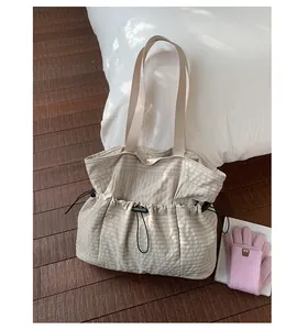 Lässige beige karierte Canvas-Einkaufstasche mit Kordelzug auf einem Holzboden
