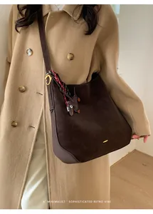 Elegante Retro Umhängetasche aus dunkelbraunem Wildleder passend zu einem beigem Mantel