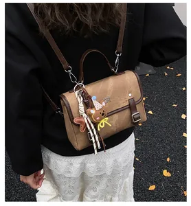 Back view of a vintage brown women's commuter backpack with cute bear and star charms