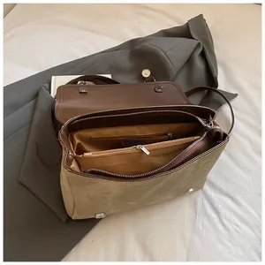 Interior detail of a vintage brown and khaki backpack with multiple compartments.