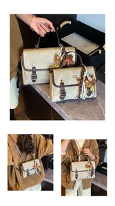 Vintage canvas and leather messenger bag with bear charm detail shown in use