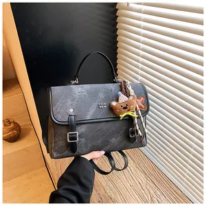 Premium textured grey women's shoulder bag with cute bear charm and silver buckle details