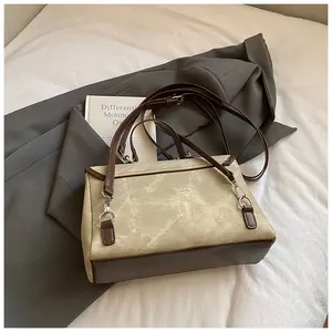 Back view of textured beige canvas and brown leather handbag for commuting