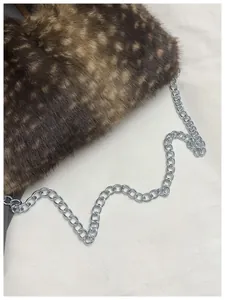 Détail d'un sac à main en fausse fourrure tachetée avec une chaîne en métal argenté élégante
