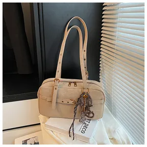 Vintage beige underarm shoulder bag for women with adjustable strap and decorative charm