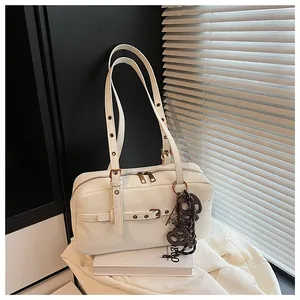 Vintage white leather underarm bag with metal buckle straps and decorative charm detail.