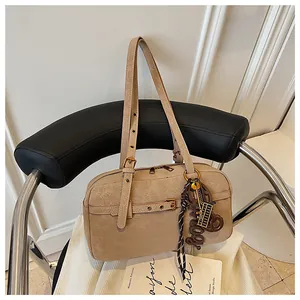 Detailed view of vintage beige underarm bag with textured leather and metal hardware