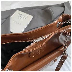 Detailed view of the smooth metal zipper and spacious interior of this brown vintage tote bag.