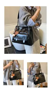 Close-up views of black retro shiny tote bag showing material texture and charms