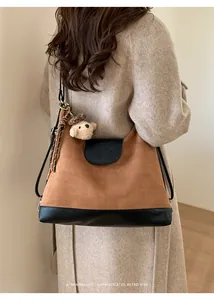 Vista trasera de una modelo con una mochila de gamuza marrón y un oso de peluche
