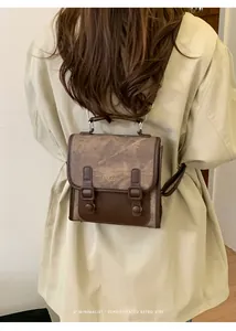 Elegante zaino retrò con motivo marmorizzato abbinato a un trench beige minimalista.