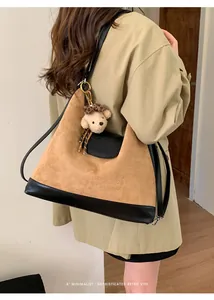 Vista detallada de una modelo con una mochila retro de gamuza marron y amuleto de oso