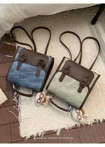 Dettaglio di due zaini in stile retrò blu e verdi con cinghie in pelle marrone