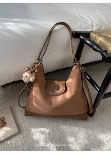 Bolso de hombro retro de ante marrón con un lindo amuleto de osito de peluche