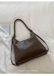 Vista detallada de una mochila marrón vintage de gran capacidad sobre una tela blanca