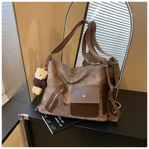 Dettaglio di uno zaino tote vintage color-block con un portachiavi a forma di orsetto