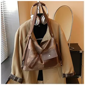 Borsa hobo marrone vintage su un trench beige in un ambiente urbano accogliente