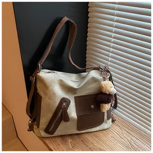 Dettaglio di una borsa tote multifunzionale vintage con ciondolo a forma di orsetto