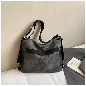 Vista dettagliata di una grande borsa tote in tela grigia retrò con cinghie nere.