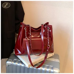 Elegant burgundy glossy faux leather tote bag featuring a chain strap and front pocket