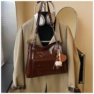 Vintage large capacity brown leather tote bag with chain strap styled with a beige trench coat