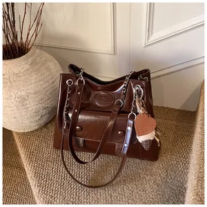 Vintage large brown commute tote bag with chain strap and cute heart plush charm.