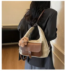 Macro view showing the side profile and plush charm of the beige hobo tote bag