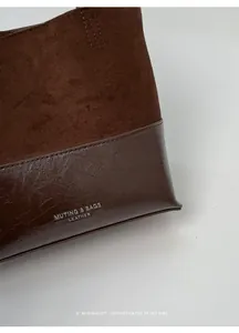 Macro view of a brown tote bag showing premium suede and glossy leather textures