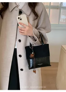 Detailed view of the black retro suede and leather patchwork handbag for women stylish.