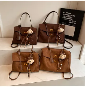 Detailed view of vintage frosted suede handbags in brown and coffee with bear charms