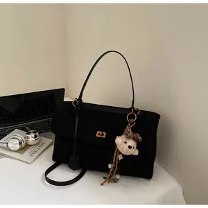 Vintage black frosted suede handbag with cute bear keychain and elegant gold-tone lock