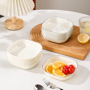Square cream-colored snack plates and bone spit dishes on a wooden serving tray