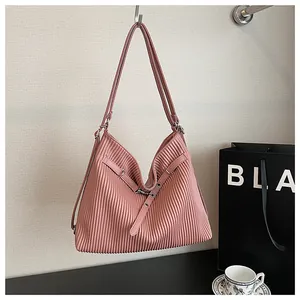 Detailed view of pink pleated hobo bag hanging on a hook in a lifestyle setting