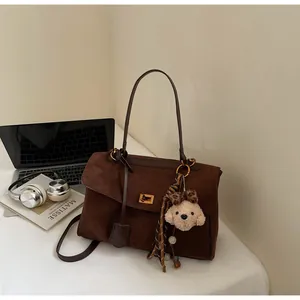 Vintage brown frosted suede shoulder bag with puppy keychain in lifestyle setting