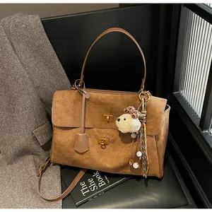 Elegant vintage brown frosted commuting handbag featuring a cute plush bear charm