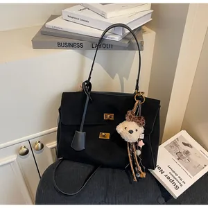Detailed view of high-quality black frosted suede tote bag with cute teddy bear charm
