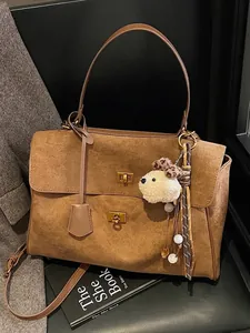 Vintage brown matte commuter shoulder bag with elegant turn-lock closures and plush charm